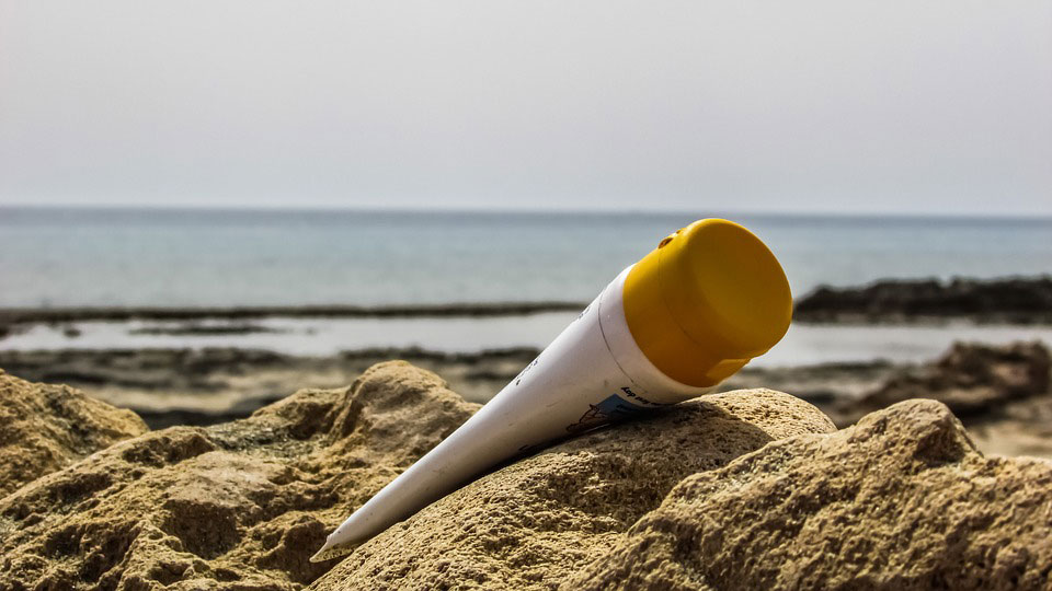 Un tube de crème solaire sur le sable