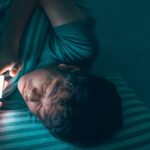 Un garçon qui regarde sont téléphone la nuit.