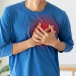 Personne en détresse tenant sa poitrine lors d’une crise cardiaque, visage non visible