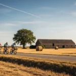 Cyclistes du Tour de France 2025 roulant à travers un paysage rural sec et ensoleillé