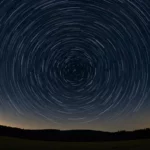 Traînées d’étoiles visibles dans le ciel nocturne, formant des cercles concentriques lors d’une longue pose photo, illustrant une pluie de météores