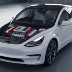Tesla Model 3 blanche avec moteur thermique visible sous le capot