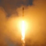 Fusée traversant un épais nuage orange au moment de son décollage