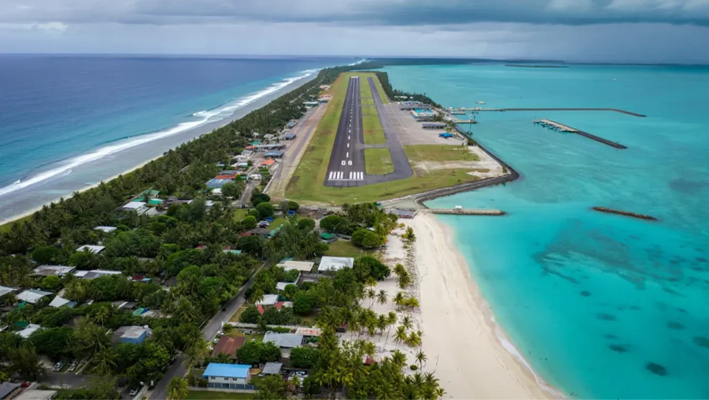 Piste d’atterrissage longeant l’océan avec des plages de sable blanc et des eaux turquoise