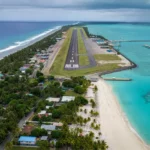 Piste d’atterrissage longeant l’océan avec des plages de sable blanc et des eaux turquoise