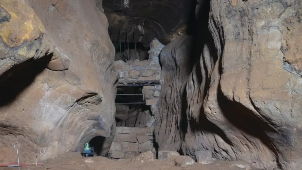 Entrée rocheuse d’une grotte préhistorique mise au jour par des archéologues.