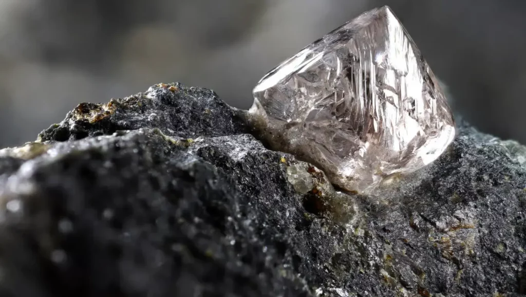 Un diamant brut encore incrusté dans la roche, tel qu’il apparaît dans la nature.