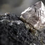 Un diamant brut encore incrusté dans la roche, tel qu’il apparaît dans la nature.