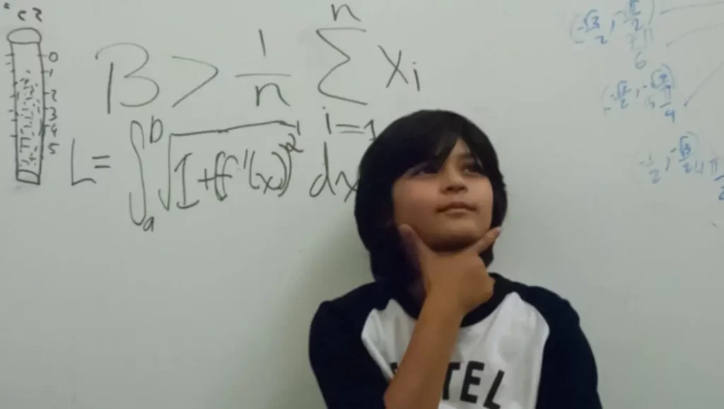 A thoughtful teenager considers his future in front of a board filled with complex mathematical formulas.