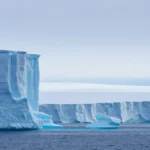 Immense iceberg bleu à la dérive dans l’océan Antarctique.