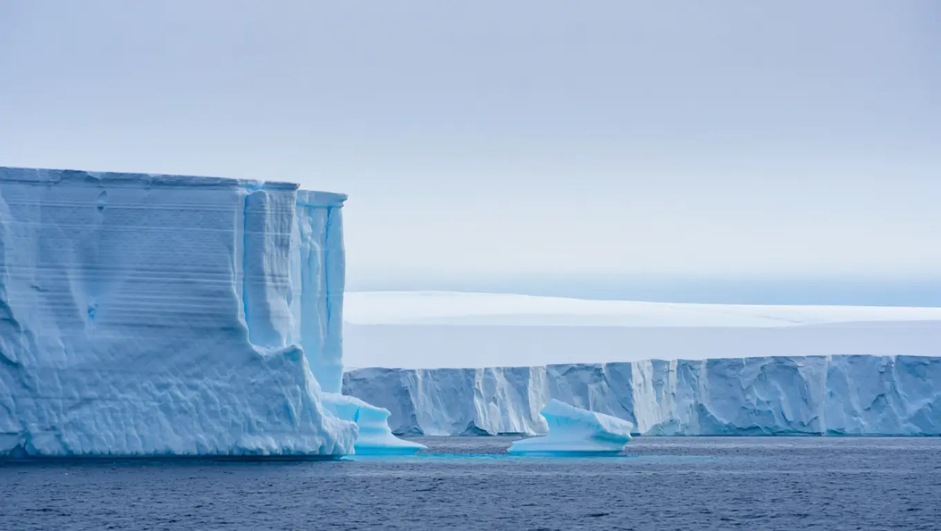 Immense iceberg bleu à la dérive dans l’océan Antarctique.