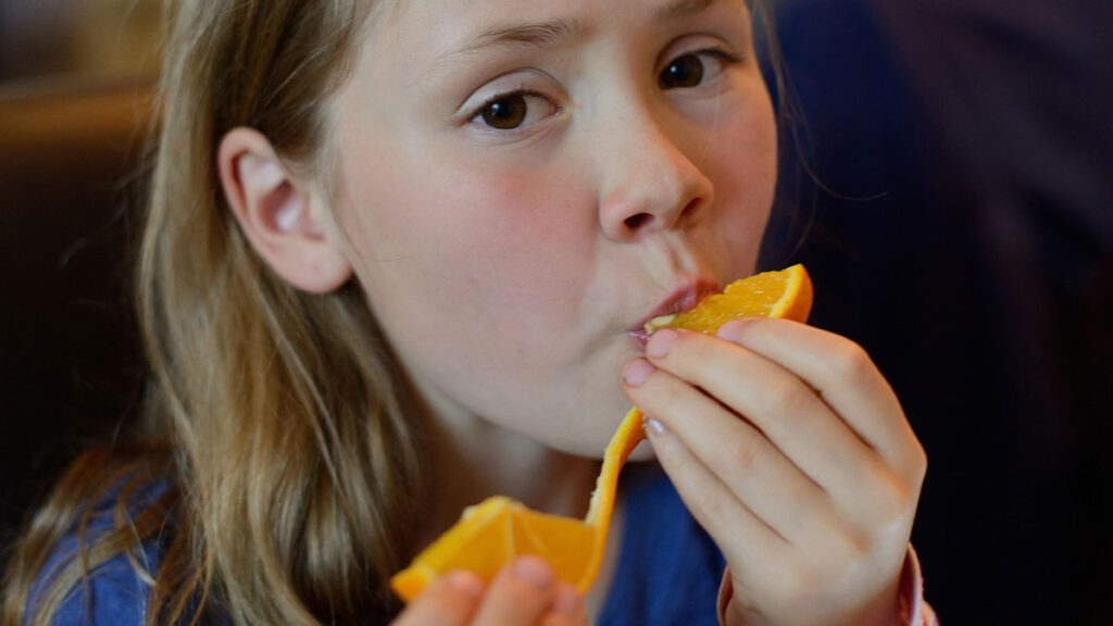 Enfant qui mange une orange