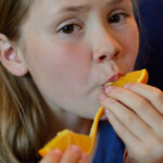 Enfant qui mange une orange