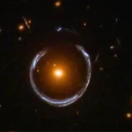 Image astronomique montrant un anneau d’Einstein lumineux formé par une galaxie lointaine déformée par la gravité, observé par le télescope James Webb.