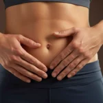 Gros plan sur l’abdomen d’une personne avec les mains posées autour du nombril, illustrant une étude scientifique sur la structure anatomique sous-cutanée.