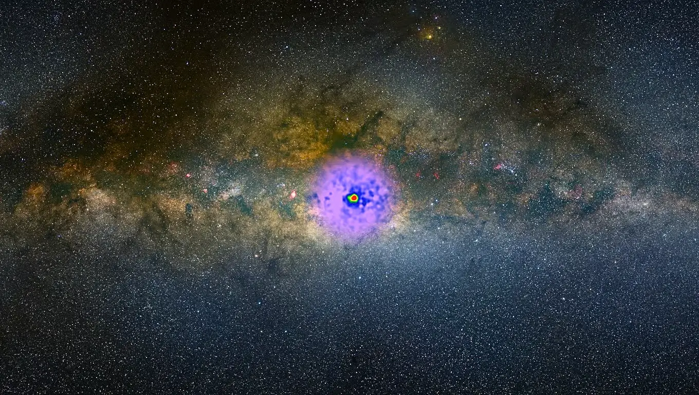Image du centre lumineux de la Voie lactée avec une émission d’énergie colorée en violet, illustrant une possible trace de matière noire.
