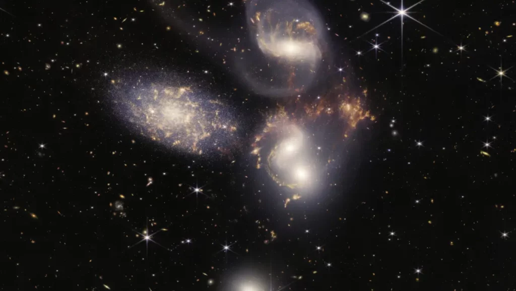 Image capturée par le télescope spatial James Webb montrant un amas de galaxies en interaction, révélant un monstre galactique aux confins de l’univers observable.