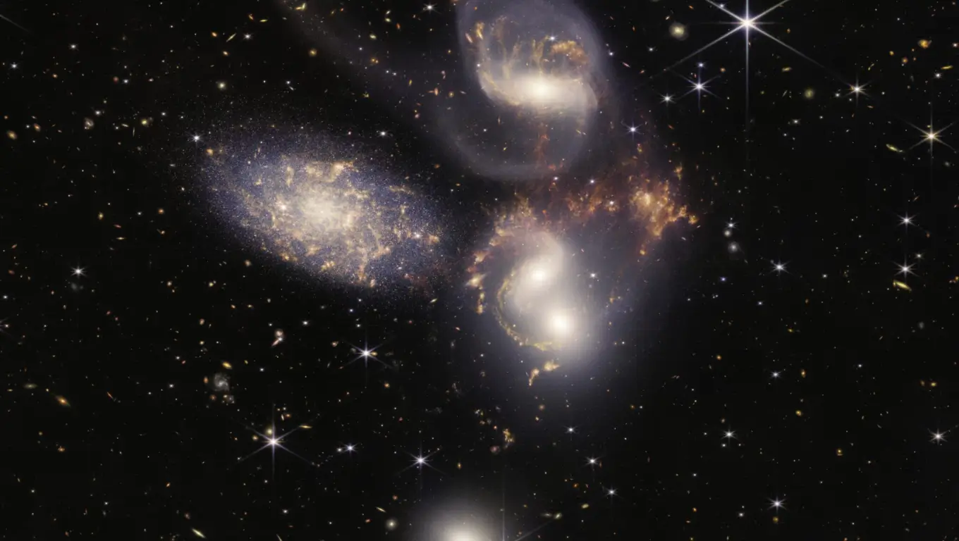 Image capturée par le télescope spatial James Webb montrant un amas de galaxies en interaction, révélant un monstre galactique aux confins de l’univers observable.