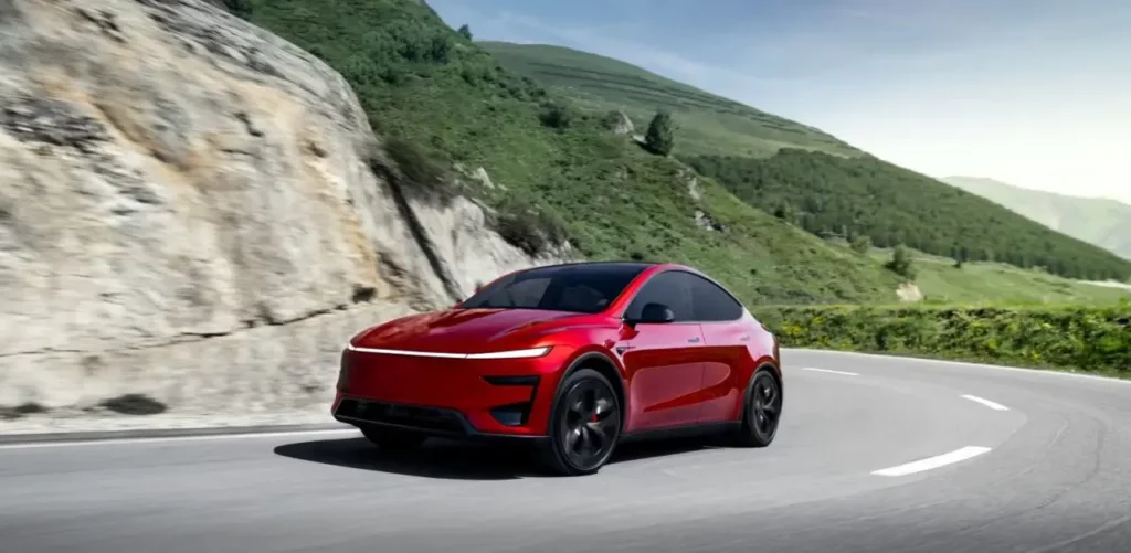 Voiture électrique rouge sportive roulant sur une route de montagne, design futuriste et aérodynamique.