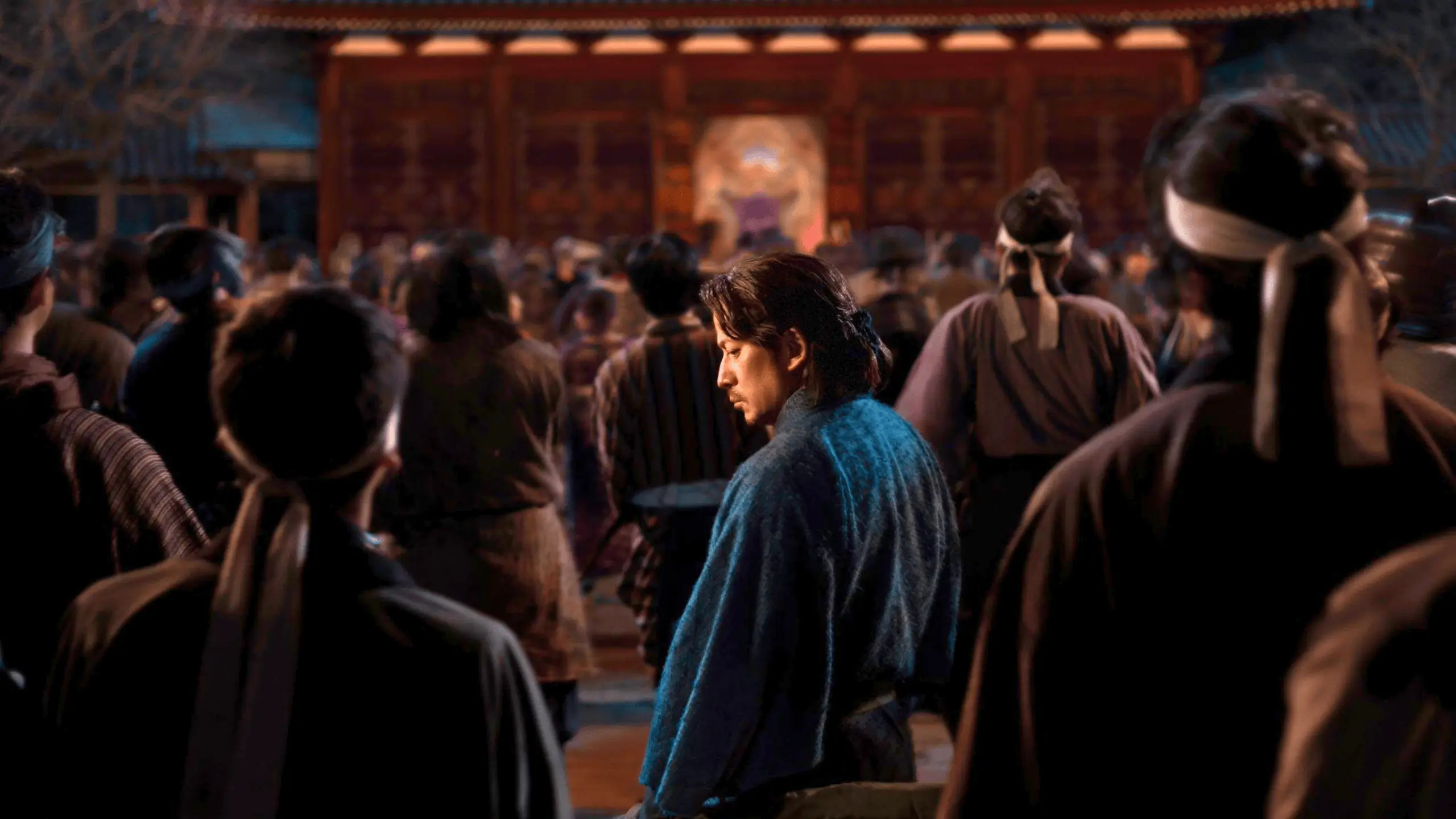 Homme en vêtement traditionnel japonais au centre d’une foule dans un palais