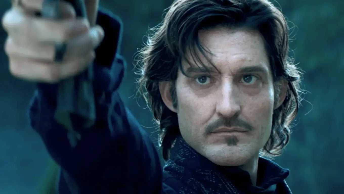 Homme au regard sérieux pointant une arme vers l’avant, dans un décor sombre.