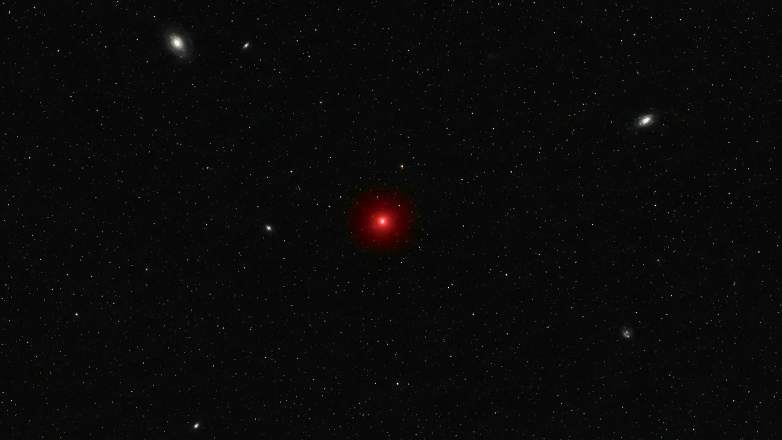 Champ profond de l’Univers montrant un point lumineux rouge isolé au milieu de galaxies lointaines et d’un fond étoilé sombre