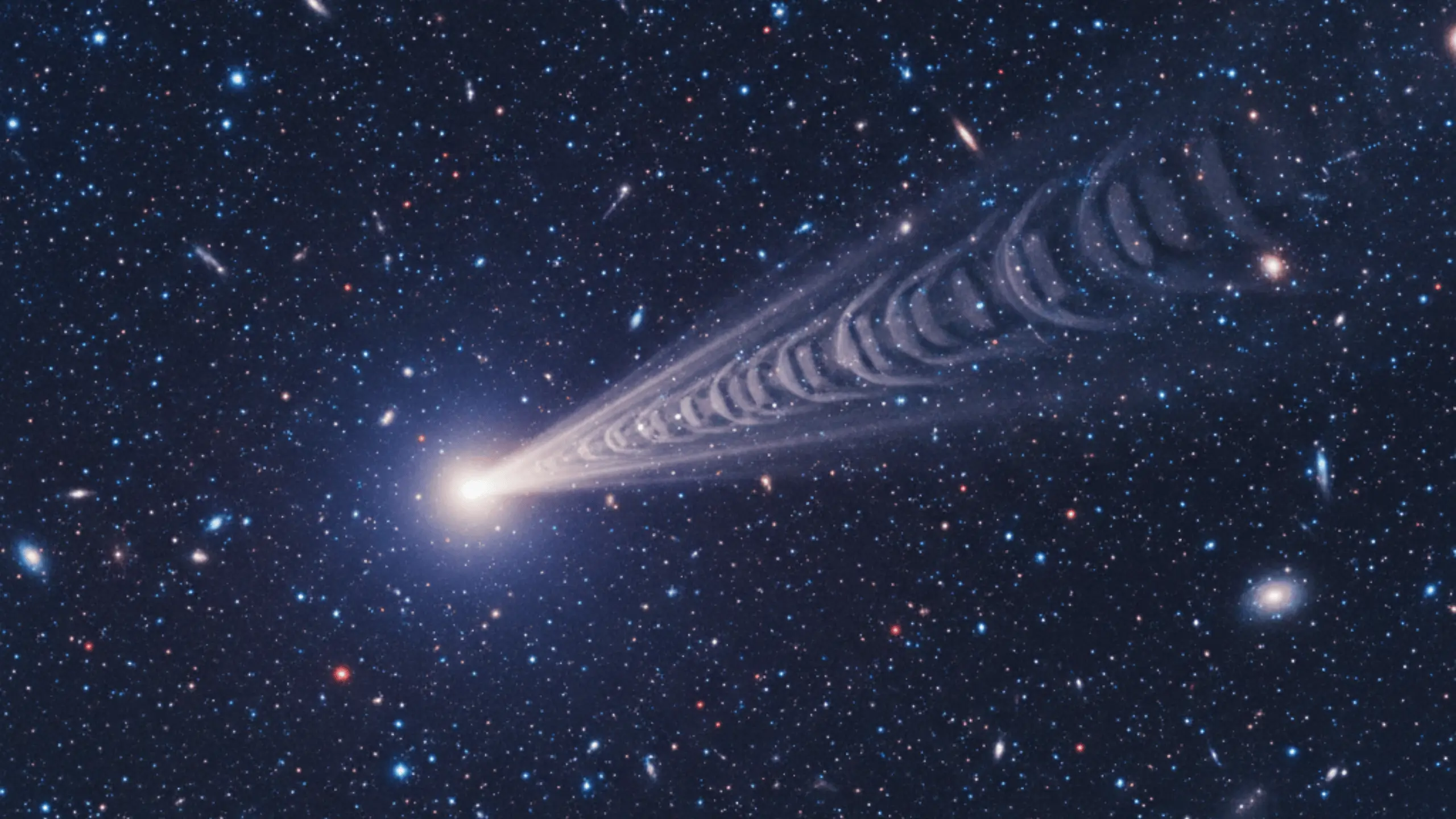 Objet stellaire ou galaxie lumineuse projetant un long jet de matière effilé avec une série d'anneaux visibles, évoquant une onde de choc ou une hélice cosmique, à travers un fond d'espace profond rempli d'étoiles et de galaxies lointaines. Photo d'astronomie, phénomène galactique, nébuleuse spirale, univers.