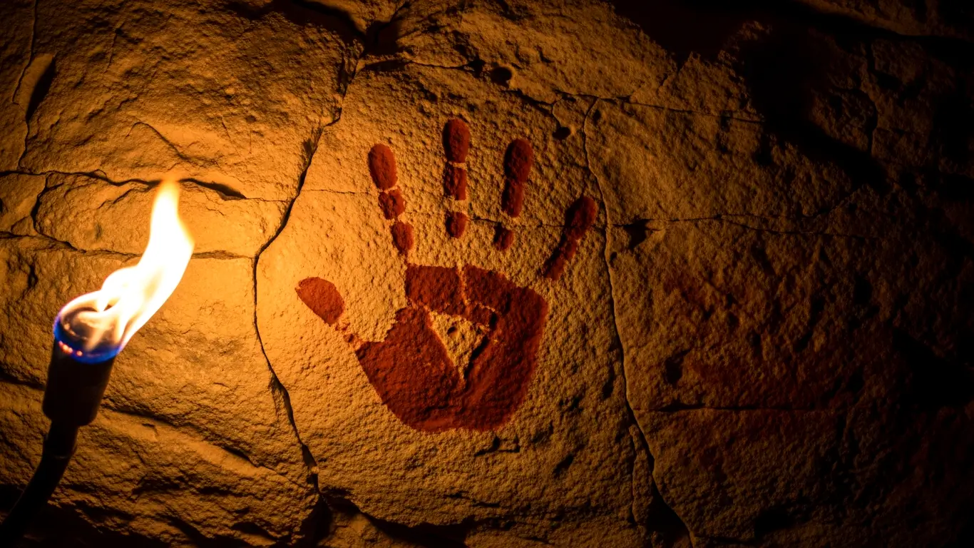 Peinture rupestre main négative ocre rouge sur paroi calcaire grotte