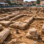 Vue d’un site archéologique à Fano, en Italie, avec des fondations antiques et des colonnes effondrées mises au jour au centre d’une place urbaine.