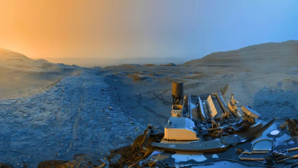 Panorama martien capturé par le rover Curiosity, montrant un paysage aride sous deux lumières contrastées : bleue et dorée.