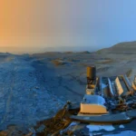 Panorama martien capturé par le rover Curiosity, montrant un paysage aride sous deux lumières contrastées : bleue et dorée.