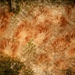 Des empreintes de mains préhistoriques au pochoir sur une paroi rocheuse dans une grotte de Sulawesi, en Indonésie.