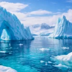 Des icebergs majestueux flottent dans une mer glacée aux reflets turquoise, sous un ciel limpide en Arctique.
