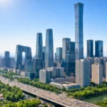 Skyline moderne d’une grande ville chinoise sous un ciel parfaitement bleu et dégagé, avec des infrastructures industrielles visibles au loin.