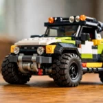 Véhicule tout-terrain LEGO équipé de pneus noirs crantés, photographié sur une table en bois avec une image nette et détaillée.
