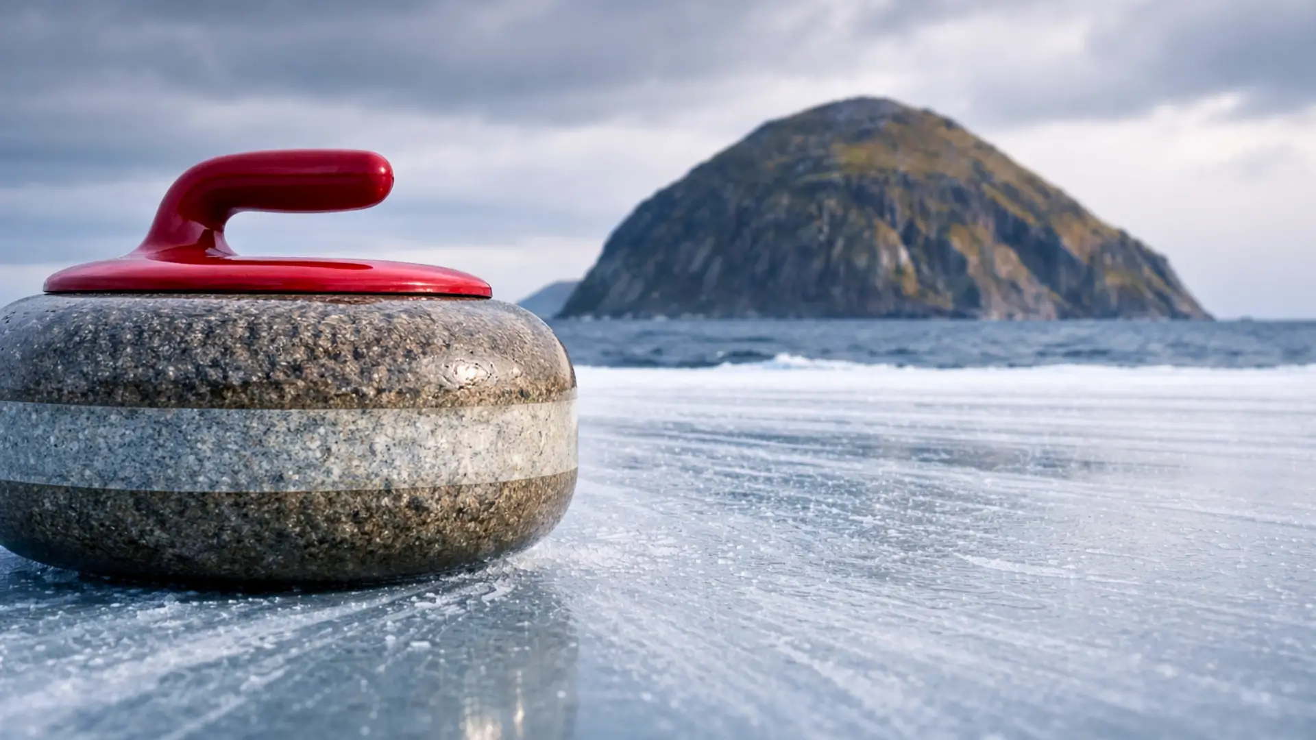 Pierre de curling en granite sur la glace avec l’île volcanique d’Ailsa Craig en arrière-plan sous un ciel écossais nuageux.