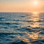 Surface de l’océan au coucher du soleil illustrant la chaleur stockée par les mers et leur rôle dans l’inertie climatique.