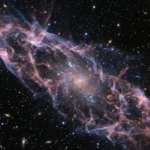 Une minuscule galaxie naine apparaît dans un vaste courant de gaz intergalactique, avec la trace lumineuse d’une collision d’étoiles à neutrons dans l’espace profond.