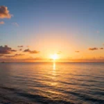Lever de soleil sur l’océan avec reflets dorés sur l’eau et nuages dans le ciel