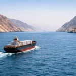Cargo transportant des engrais naviguant dans le détroit d’Ormuz entre des montagnes arides