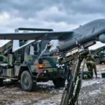 Un drone kamikaze européen est positionné sur un lanceur terrestre dans une base militaire, prêt au déploiement.