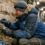 Scientifique prélevant un échantillon de glace dans un tunnel de pergélisol en Alaska