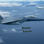 F-15E américain larguant des bombes intelligentes lors d’un exercice militaire avec un avion radar au-dessus de la mer près de la Norvège