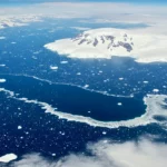 Vue aérienne d’une polynie en Antarctique formant un grand trou dans la banquise entouré de glace