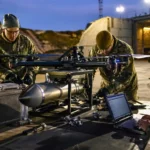 Drone militaire équipé d’une ogive anti-bunker BRAKER en cours de test sur une base avec ingénieurs et équipements techniques