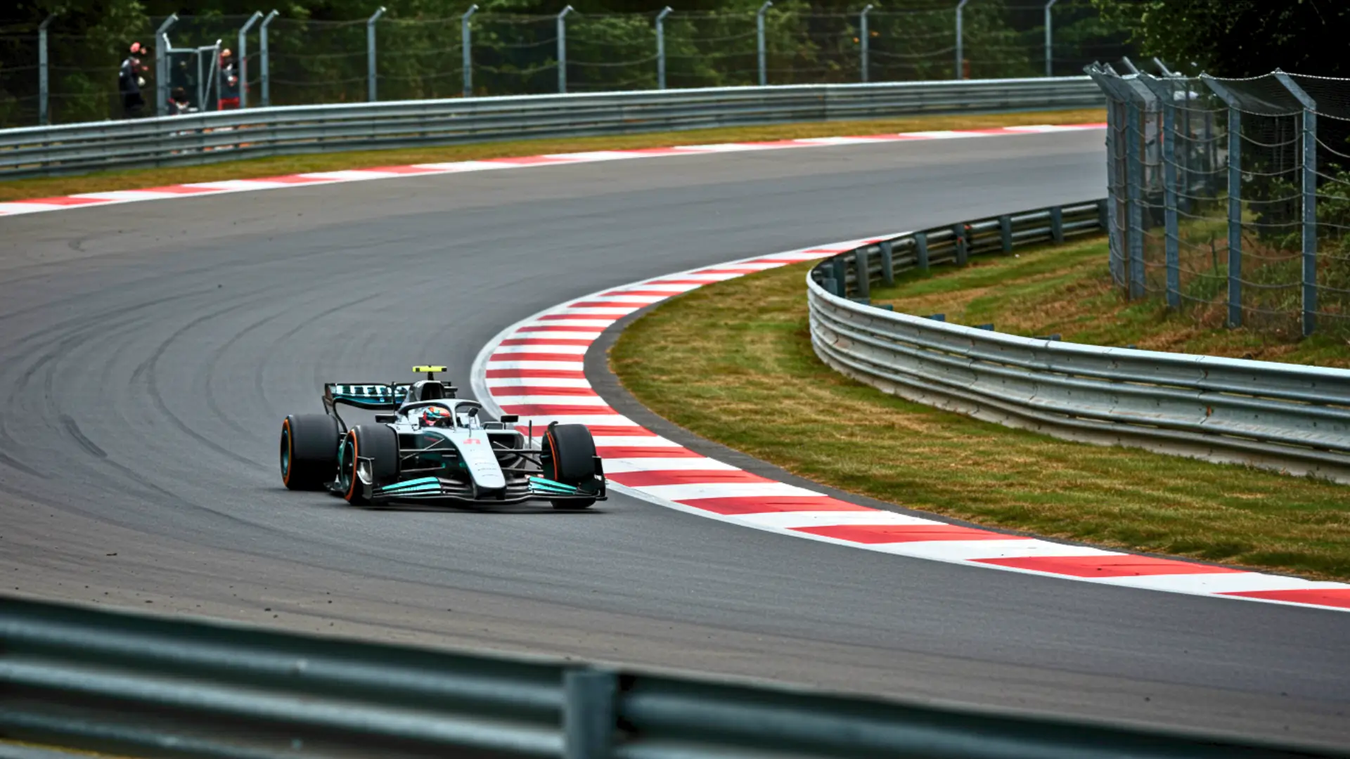 Voiture de course avec pilote roulant à grande vitesse dans un virage sur circuit automobile