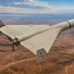 Drone Shahed-136 iranien en vol au-dessus d’un désert vu de haut