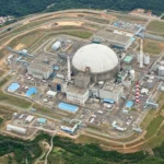 Vue aérienne d’un complexe nucléaire avec un grand dôme et des installations industrielles dans une zone rurale du Sichuan en Chine
