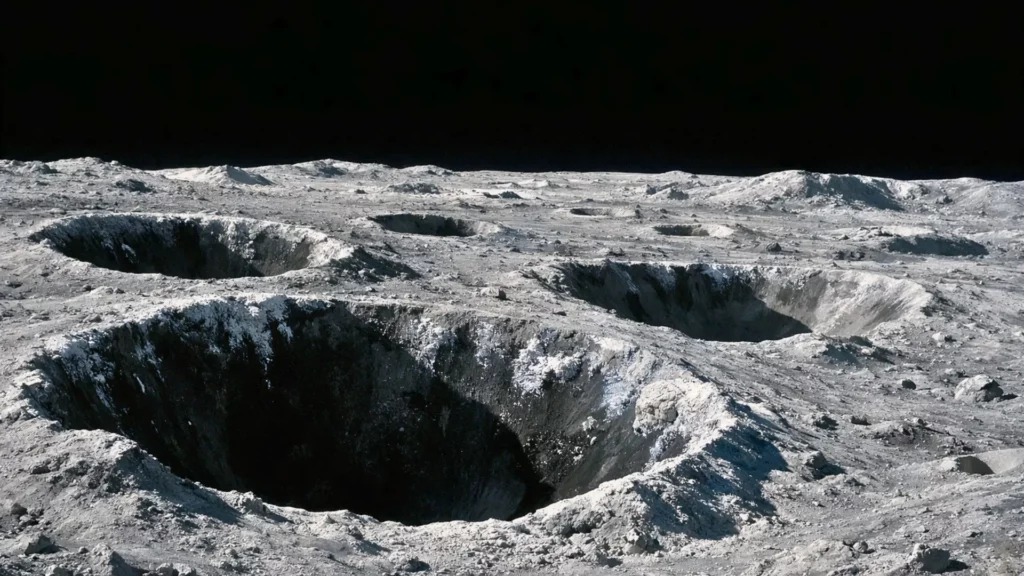Vue du pôle sud de la Lune avec de grands cratères plongés dans l’ombre permanente, entourés de régolithe gris et de fins dépôts cristallins évoquant du givre.