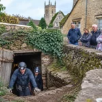 Des spéléologues explorent l’entrée d’un tunnel souterrain découvert dans le village anglais de Bloxham sous le regard des habitants.